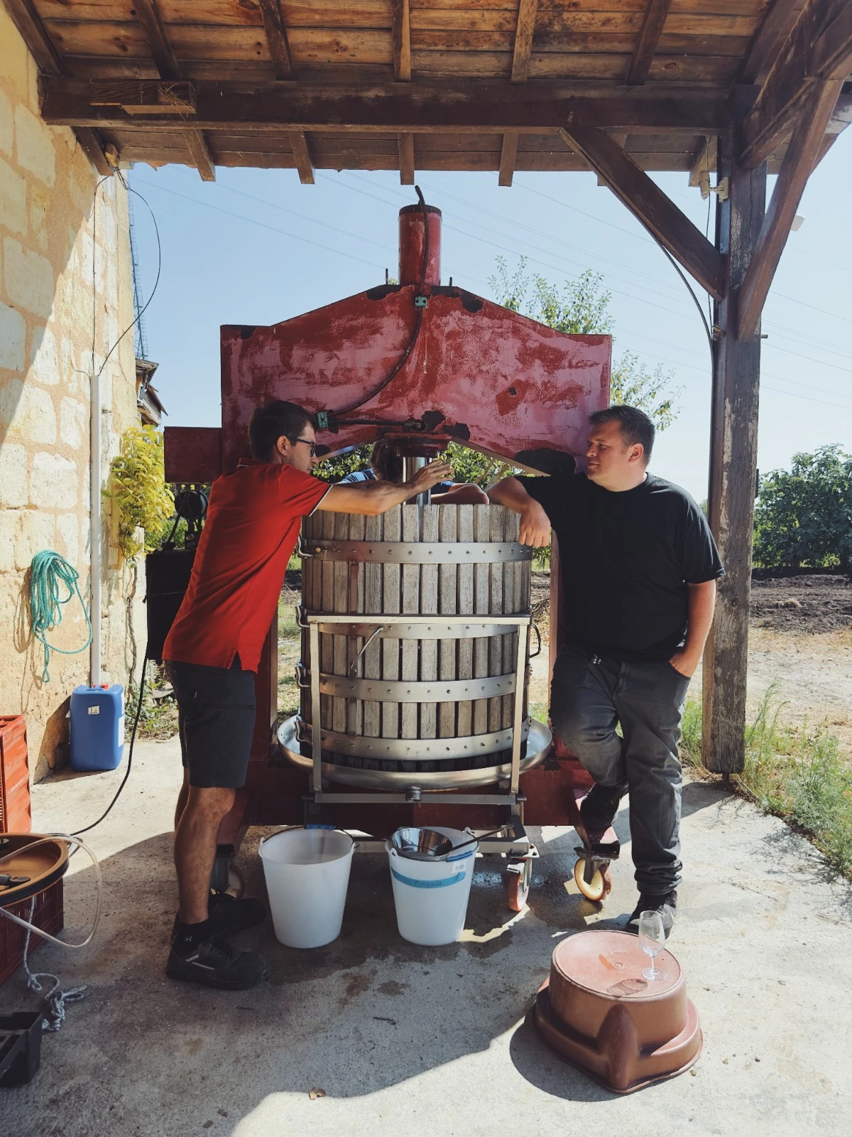 Two people sharing a moment beside the traditional basket press at Shuette