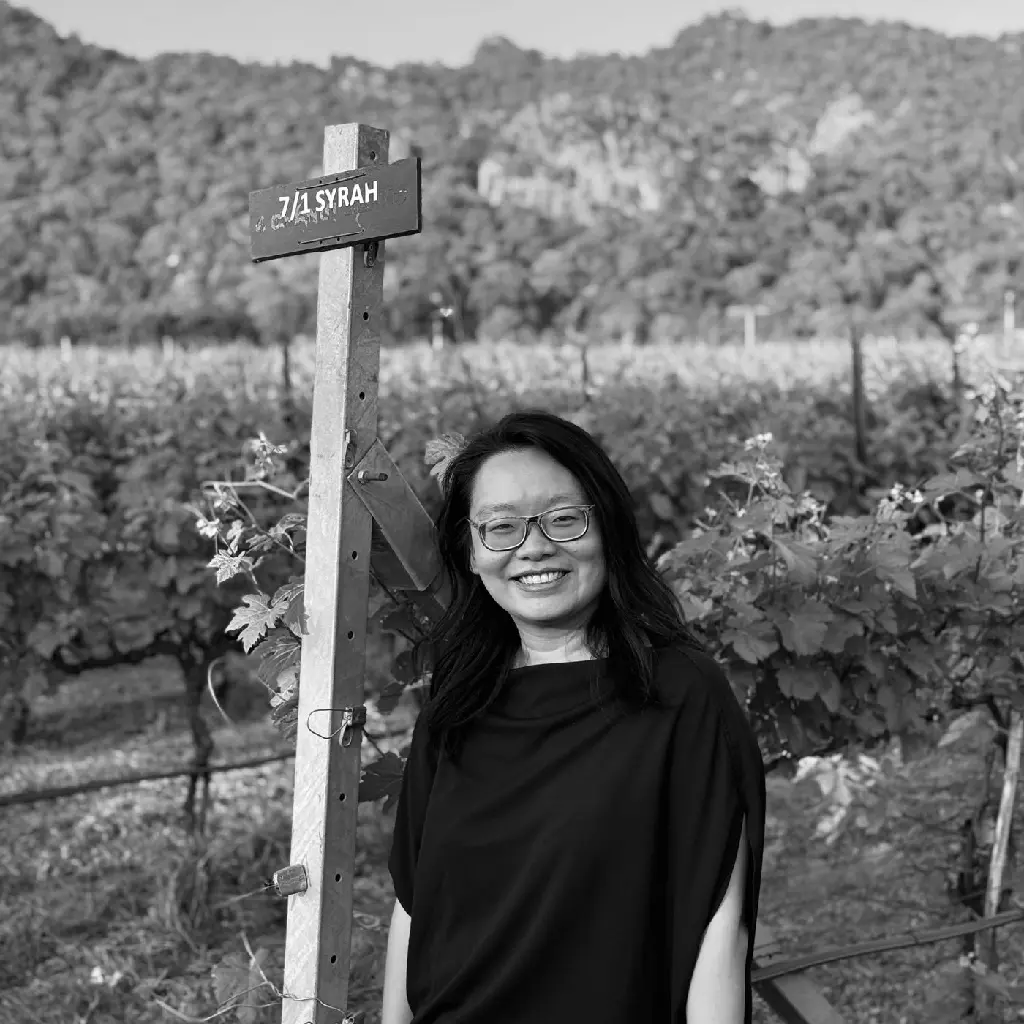 Portrait in the vineyard beside a Syrah vine marker